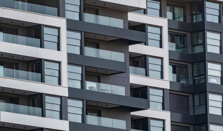 Nowoczesny blok mieszkalny z balkonami i szklanymi balustradami – elewacja budynku wielorodzinnego